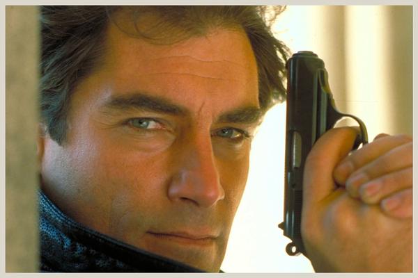 Timothy Dalton as James Bond holding Walther PPK